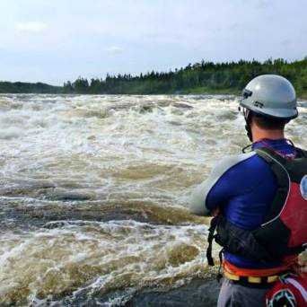 a man riding a motorcycle down a river next to a body of water