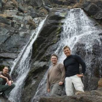 a man standing next to a waterfall