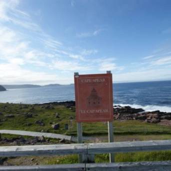 a sign on the side of a road next to a body of water