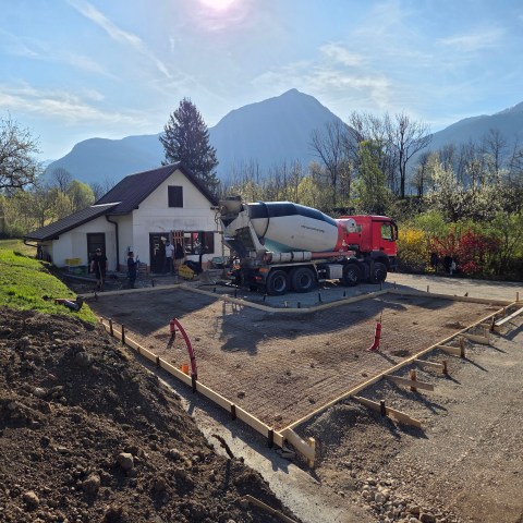Cement truck at a construction site with mountains in the background.
